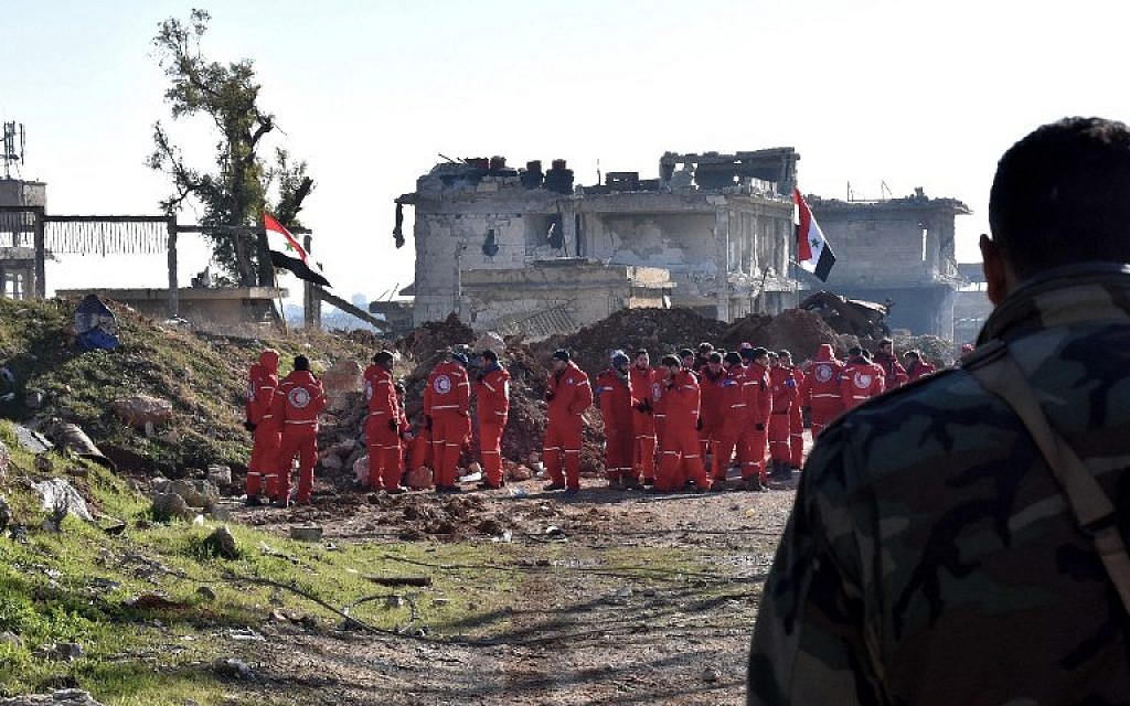 Syrian government forces and Red Crescent staff are seen in Aleppo's Ramoussa district as the evacuation of civilians from eastern Aleppo continues on December 20, 2016. (AFP PHOTO / GEORGE OURFALIAN)