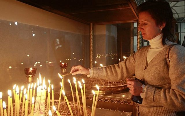 A Christian woman lights a candle at the Church of the Nativity, believed to be the birthplace of Jesus Christ, in the West Bank city of Bethlehem on December 20, 2016. (AFP PHOTO / MUSA AL SHAER)