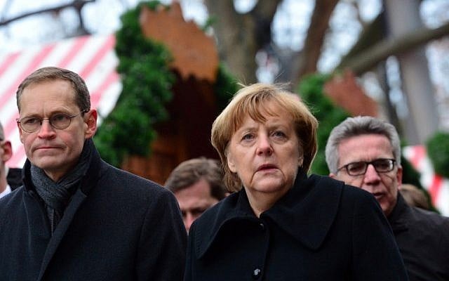 German Chancellor Angela Merkel (C), Berlin Mayor Michael Mueller (L) and German Interior Minister Thomas de Maiziere (R) visit the site of a terror attack at a Christmas market in Berlin on December 20, 2016. (AFP PHOTO/DPA/Maurizio Gambarini) 