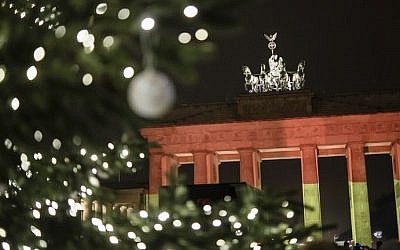 The Brandenburg Gate is seen in the colors of the German flag in Berlin on December 20, 2016 one day after a truck crashed into a Christmas market. (AFP Photo/Clemens Bilan)