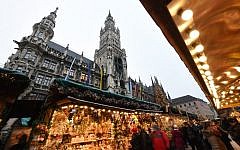 People walk between booths of the Christmas market in front of the city hall at the Marienplatz in Munich, southern Germany, on December 20, 2016, one day after a truck crashed into a Christmas market in Berlin.  (AFP PHOTO / Christof STACHE)