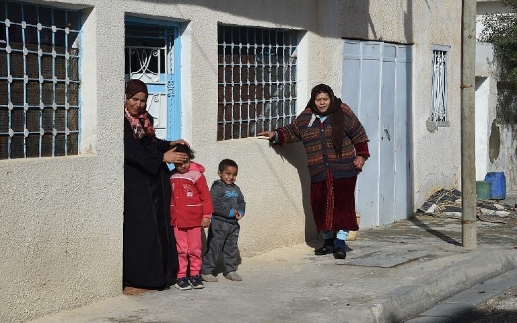 Neighbors watch as the media gathers at the family home of Anis Amri, the prime suspect in the deadly Berlin truck attack, in the Tunisian town of Oueslatia on December 22, 2016. (AFP PHOTO/FETHI BELAID)