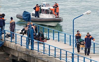Russian rescuers carry a stretcher with passenger belongings after a Russian military plane crashed in the Black Sea, on a pier outside Sochi, on December 25, 2016. (AFP Photo/Stringer)