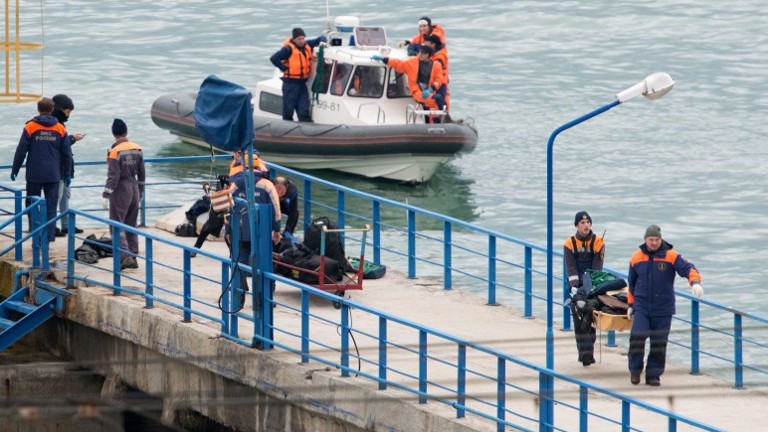 Russian rescuers carry a stretcher with passenger belongings after a Russian military plane crashed in the Black Sea, on a pier outside Sochi, on December 25, 2016. (AFP Photo/Stringer) Russian rescuers carry a stretcher with passenger belongings after a Russian military plane crashed in the Black Sea, on a pier outside Sochi, on December 25, 2016. (AFP Photo/Stringer)