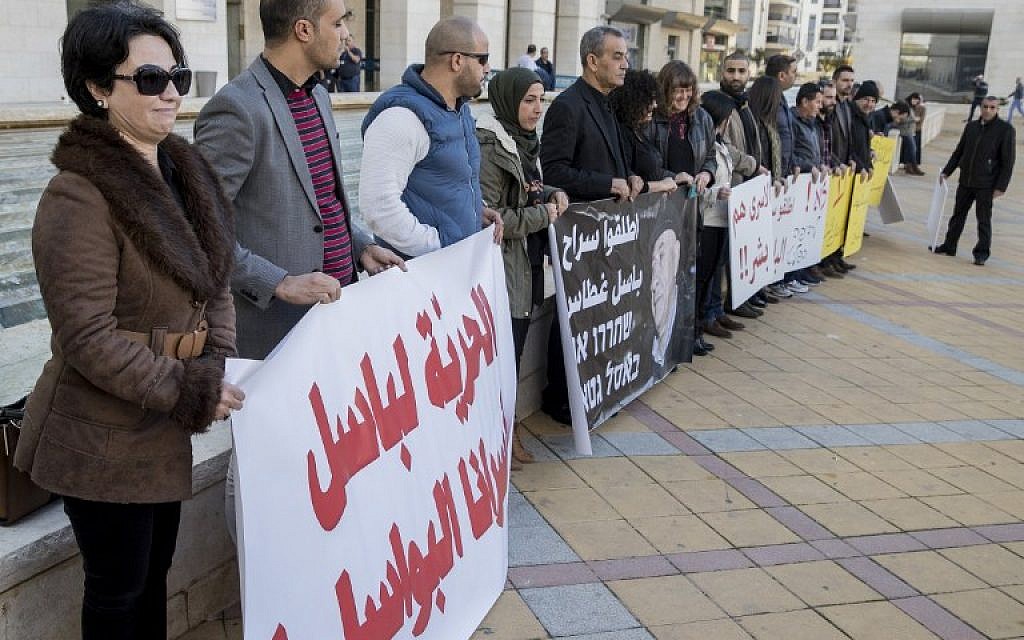 Protesters demonstrate outside Rishon Lezion Magistrate's Court as Arab MK Basel Ghattas attends a remand hearing, on December 26, 2016. (AFP PHOTO/JACK GUEZ)