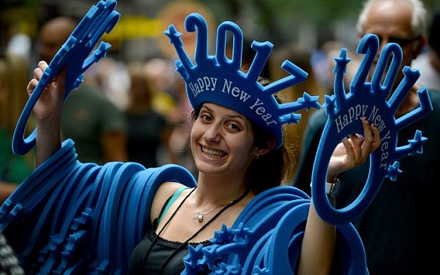 A woman sells "Happy New Year 2017" headwear on a shopping street in Sydney, Australia on December 30, 2016. AFP PHOTO / Peter PARKS