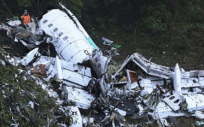 Rescue workers stand at the wreckage site of a chartered airplane that crashed in a mountainous area outside Medellin, Colombia, Tuesday, Nov. 29, 2016. The plane was carrying the Brazilian first division soccer club Chapecoense team that was on it's way for a Copa Sudamericana final match against Colombia's Atletico Nacional. (AP/Luis Benavides)