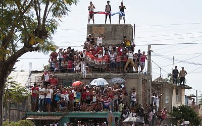 People stand on a building to get a better view of the funeral procession carrying the ashes of Fidel Castro, the last stage of the convoy arriving to Santiago, Cuba, Saturday, December 3, 2016. (Fernando Medina/Cubahora via AP) People stand on a building to get a better view of the funeral procession carrying the ashes of Fidel Castro, the last stage of the convoy arriving to Santiago, Cuba, Saturday, December 3, 2016. (Fernando Medina/Cubahora via AP)