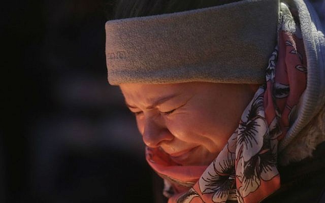 A woman is illuminated by candles as she cries in Berlin, Germany, Tuesday, Dec. 20, 2016, the day after a truck ran into a crowded Christmas market nearby and killed several people. (AP Photo/Markus Schreiber)