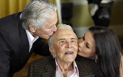 US actor Kirk Douglas, center, gets a kiss from his son Michael Douglas, left, and Michael's wife Catherine Zeta-Jones during his 100th birthday party at the Beverly Hills Hotel on December 9. 2016, in Beverly Hills, Calif. (Chris Pizzello/Invision/AP)