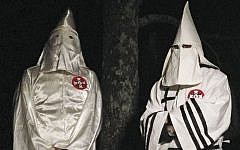 Illustrative: In this Friday, December 2, 2016, photo, two masked Ku Klux Klansmen stand on a muddy dirt road during an interview near Pelham, North Carolina. (AP Photo/Jay Reeves)