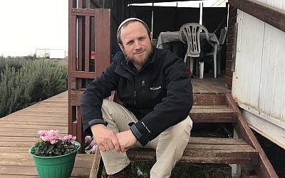 Eli Greenberg sitting outside his home in the West Bank outpost of Amona, Dec. 13, 2016. (Andrew Tobin/JTA)