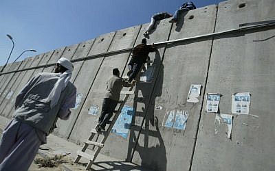 Palestinian worshipers climb over a section of Israel's security barrier from the West Bank village of A-Ram towards Jerusalem on their way to pray in the Al Aqsa Mosque, Friday, Oct. 20, 2006. (Credit Pierre Terdjman / Flash90)