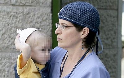 A nurse carries a suspected victim of abuse by his mother, Jerusalem,  July 26, 2009. (Abir Sultan/Flash90)