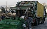 Sanitation workers prepare to empty a dumpster into a garbage truck in Jerusalem, file (Kobi Gideon/Flash90)