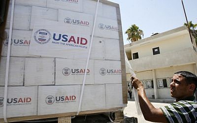 Illustrative: A Palestinian checks a truck loaded with humanitarian aid from the US as it arrives in the Palestinian town of Rafah through the Kerem Shalom crossing between Israel and the southern Gaza Strip on August 6, 2014. (Abed Rahim Khatib/Flash90)