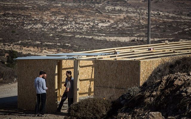 Young Israeli men build a structure in the West Bank outpost of Amona on November 28, 2016. The structure is meant to house supporters for when the state decides to evacuate the outpost, which was built on private Palestinian land. (Hadas Parush/Flash90) Young Israeli men build a structure in the West Bank outpost of Amona on November 28, 2016. The structure is meant to house supporters for when the state decides to evacuate the outpost, which was built on private Palestinian land. (Hadas Parush/Flash90)