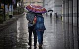 Illustrative: A couple walks with an umbrella in the rain in Tel Aviv, on December 1, 2016. (Nati Shohat/Flash90)