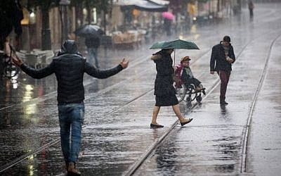 Illustrative: People walk in the rain on Jaffa Street in downtown Jerusalem on December 1, 2016. (Yonatan Sindel/Flash90)