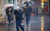 People walk in the rain on Jaffa street in downtown Jerusalem on December 1, 2016. (Yonatan Sindel/Flash90)