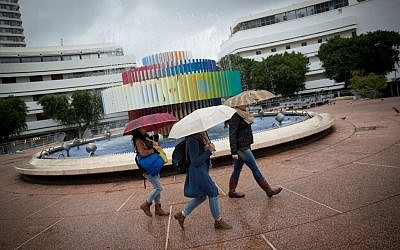 Israelis walk in the rain on Dizengoff Street in Tel Aviv on December 2, 2016 (Miriam Alster/Flash90)
