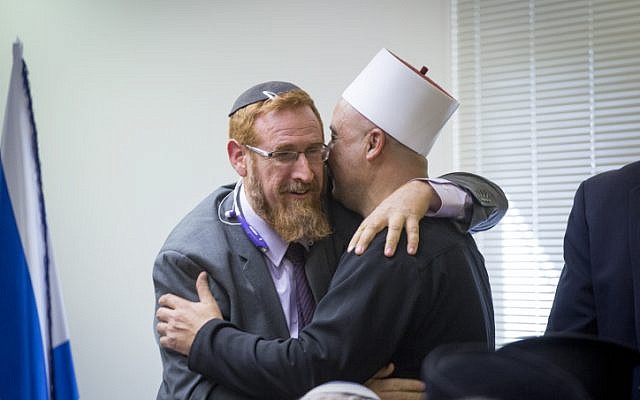 Likud MK Yehudah Glick embraces a Druze religious leader during an emergency meeting over the muezzin law, a bill which intends to ban loudspeakers at mosques, in the Israeli parliament on December 05, 2016. (Miriam Alster/FLASH90) Likud MK Yehudah Glick embraces a Druze religious leader during an emergency meeting over the muezzin law, a bill which intends to ban loudspeakers at mosques, in the Israeli parliament on December 05, 2016. (Miriam Alster/FLASH90)