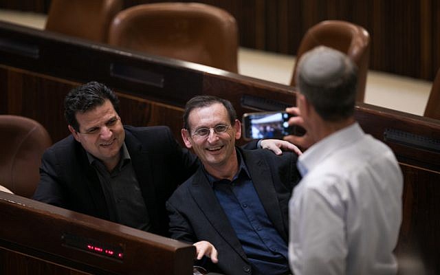 Joint List parliament member Dov Khenin and leader of the Joint List Ayman Odeh pose for a picture during a vote on the so-called Regulation Bill on December 7, 2016. (Yonatan Sindel/Flash90)