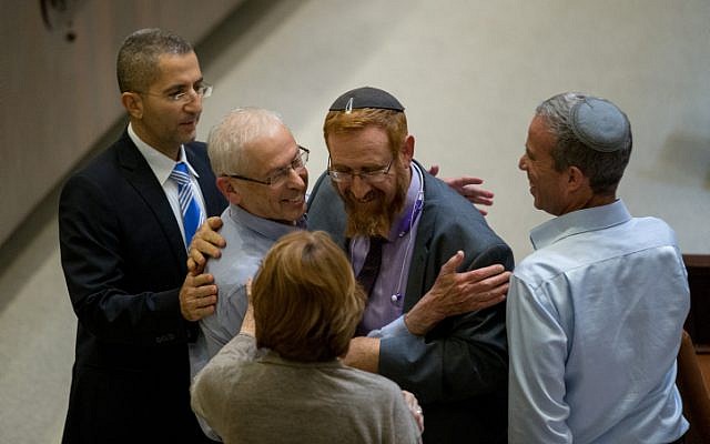 Likud MK Benny Begin is congratulated by Likud MK Yehudah Glick during a vote on the so-called Regulation Bill on December 7, 2016. (Yonatan Sindel/Flash90)