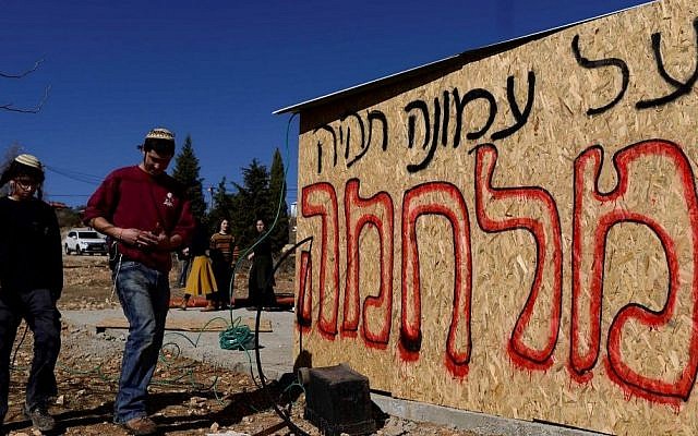 Jewish youth prepare places for people to sleep in as they plan to resist the evacuation of Amona in the West Bank, on December 9, 2016. The writing on the structure reads "there will be a war for Amona." (Tomer Neuberg/Flash90) Jewish youth prepare places for people to sleep in as they plan to resist the evacuation of Amona in the West Bank, on December 9, 2016. The writing on the structure reads "there will be a war for Amona." (Tomer Neuberg/Flash90)