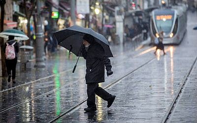 People walk in the rain on Jaffa Street in downtown Jerusalem on December 14, 2016. (Yonatan Sindel/Flash90)