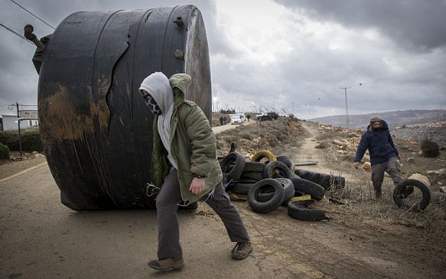 A Jewish teenager prepares to barricade the entrance to the Amona outpost in the event of its evacuation on December 15, 2016, after residents voted against a peaceful evacuation. (Yonatan Sindel/Flash90)