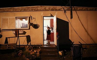 An Israeli girl stands at the entrance to her home in the settlement of Amona in the West Bank, on December 17, 2016. (Miriam Alster/Flash90)