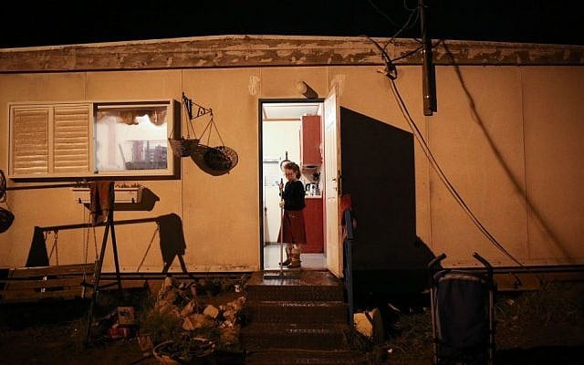 An Israeli girl stands at the entrance to her home in the settlement of Amona in the West Bank, on December 17, 2016. (Miriam Alster/Flash90)