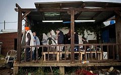 Jewish men pray early in the morning in the unauthoized outpost of Amona in the West Bank, on December 18, 2016. (Miriam Alster/Flash90)