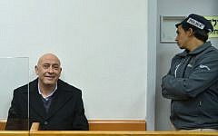 Arab Joint List member Basel Ghattas, left, is brought to court for a remand hearing after his arrest on December 22, 2016 on suspicion of smuggling cellphones to Palestinian prisoners, at the Rishon Lezion Magistrate's Court, December 23, 2016. (Avi Dishi/Flash90)