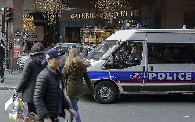 A police van is parked outside the Galeries Lafayette department store in Paris, France, Tuesday, Dec. 20, 2016, the day after a truck ran into a crowded Christmas market, killing 12 people Monday evening in Berlin, Germany. (AP Photo/Thomas Padilla)