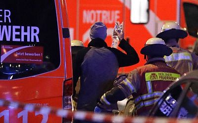 Firefighters attend an injured person after a truck ran into crowded Christmas market in Berlin, Germany, Monday, Dec. 19, 2016. (AP Photo/Michael Sohn)