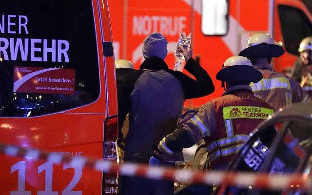 Police stand beside a damaged truck which ran into crowded Christmas market in Berlin, Germany, Monday, Dec. 19, 2016. (AP Photo/Michael Sohn)