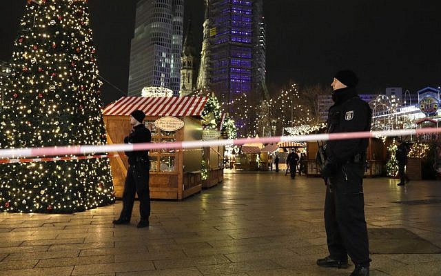 Firefighters look at a toppled Christmas tree after a truck ran into a crowded Christmas market and killed several people in Berlin, Germany, Monday, Dec. 19, 2016. (AP Photo/Michael Sohn)
