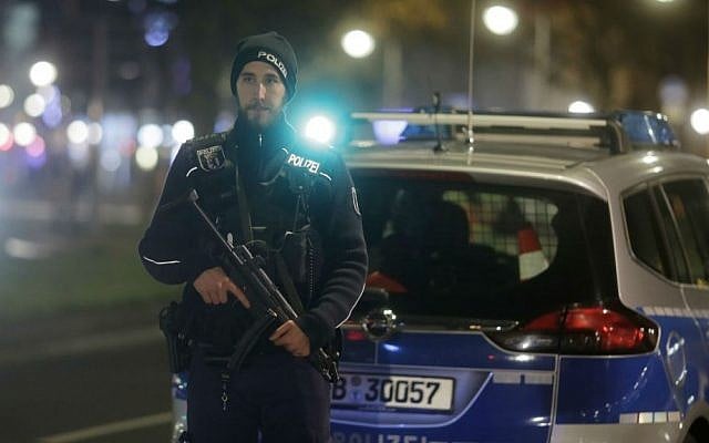 A police officer with a submachine gun stands guard after a truck ran into a crowded Christmas market in Berlin, Germany, Monday, Dec. 19, 2016. (AP Photo/Markus Schreiber)