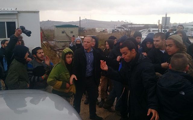 Construction Minister Yoav Galant leaving Amona surrounded by protesters who have gathered in the West Bank outpost in the hope of preventing the court-imposed evacuation, December 18, 2016. (Judah Ari Gross/The Times of Israel)