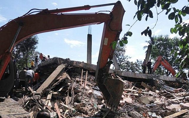 Rescuers use heavy machine to search for survivors under the rubble of a collapsed building after an earthquake in Pidie Jaya, Aceh province, Indonesia, Wednesday, Dec. 7, 2016. (AP Photo/Heri Juanda)