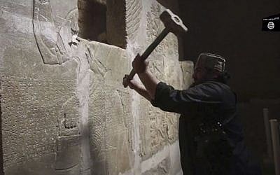 This image made from video posted online by Islamic State in April 2015 shows a man taking a sledgehammer to a stone carving at the ancient site of Nimrud near Mosul, Iraq. (Militant video via AP)