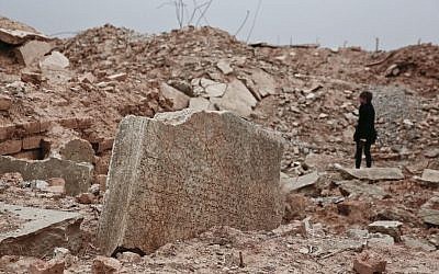 A stone tablet with cuneiform writing is seen in the foreground as UNESCO's Iraq representative Louise Haxthausen documents the damage wreaked by the Islamic State group at the ancient site of Nimrud, Iraq in this December 14, 2016, photo. (AP Photo/Maya Alleruzzo)