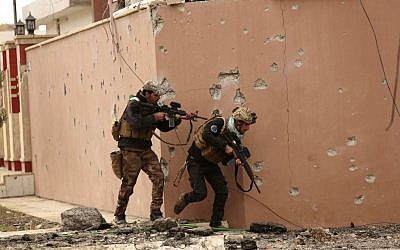 Soldiers with Iraq's elite counter-terrorism forces secure houses and streets during fighting against Islamic State militants to regain control of the eastern neighborhoods of Mosul, Iraq, Tuesday, Dec. 13, 2016. (AP Photo/Hadi Mizban)