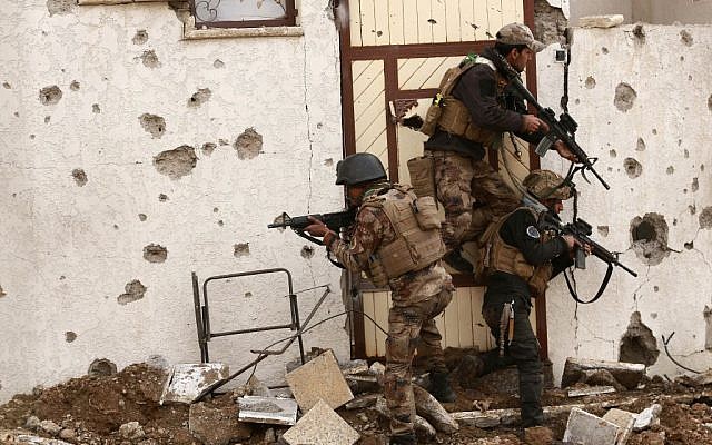 Soldiers with Iraq's elite counter-terrorism forces secure houses and streets during fighting against Islamic State militants to regain control of the eastern neighborhoods of Mosul, Iraq, Tuesday, Dec. 13, 2016. (AP Photo/Hadi Mizban)