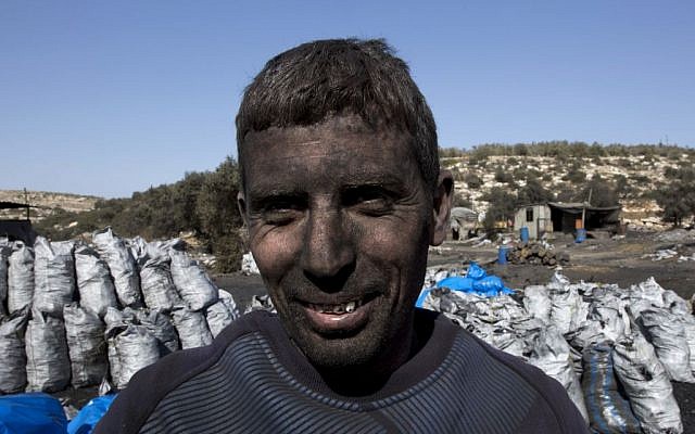 In this photo taken Monday, Nov. 21, 2016, Palestinian laborer Sami Abu Baker, 35, who has a fifteen years service in the charcoal factories, poses for a picture during a day work, in the West Bank town of Yabad, near Jenin. (Nasser Nasser/AP) In this photo taken Monday, Nov. 21, 2016, Palestinian laborer Sami Abu Baker, 35, who has a fifteen years service in the charcoal factories, poses for a picture during a day work, in the West Bank town of Yabad, near Jenin. (Nasser Nasser/AP)