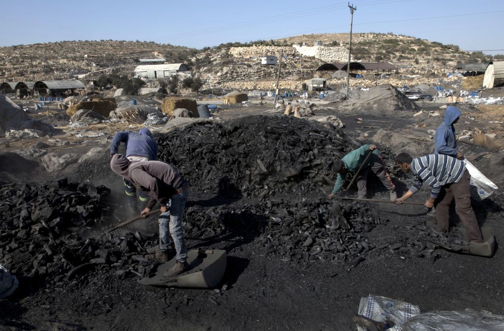 Palestinian laborers work at the site of a charcoal factory, in the West Bank town of Yabad, near Jenin. (AP Photo/Nasser Nasser) Palestinian laborers work at the site of a charcoal factory, in the West Bank town of Yabad, near Jenin. (AP Photo/Nasser Nasser)