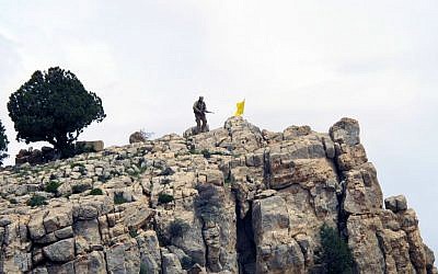 In this Saturday, May 9, 2015 file photo, a Hezbollah fighter stands on a hill next to the group's yellow flag in the fields of the Syrian town of Assal al-Ward in the mountainous region of Qalamoun, Syria. (AP Photo/Bassem Mroue, File) In this Saturday, May 9, 2015 file photo, a Hezbollah fighter stands on a hill next to the group's yellow flag in the fields of the Syrian town of Assal al-Ward in the mountainous region of Qalamoun, Syria. (AP Photo/Bassem Mroue, File)