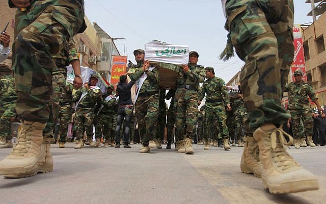  In this Saturday, April 26, 2014 file photo, mourners carry the flag-draped coffins of five militia members of a Shiite group, Asaib Ahl al-Haq, or League of the Righteous, during their funeral procession in the Shiite holy city of Najaf, 100 miles (160 kilometers) south of Baghdad, Iraq. 